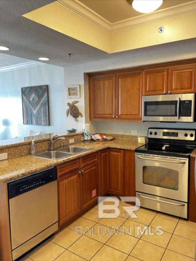 401 E Beach Blvd Unit 507, Gulf Shores, AL 36542 - kitchen with appliances with stainless steel finishes, a sink, a peninsula, ornamental molding, and light tile patterned flooring