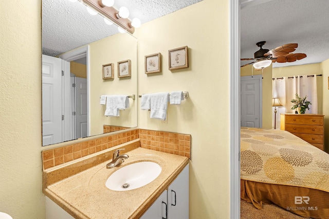 24114 Perdido Beach Blvd Unit 402, Orange Beach, AL 36561 - bathroom with tasteful backsplash, vanity, ceiling fan, and a textured ceiling