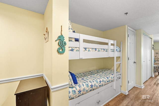 24114 Perdido Beach Blvd Unit 402, Orange Beach, AL 36561 - bedroom featuring a textured ceiling and light wood-type flooring