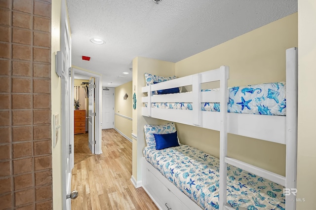 24114 Perdido Beach Blvd Unit 402, Orange Beach, AL 36561 - bedroom with a textured ceiling and light wood-type flooring