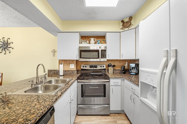 24114 Perdido Beach Blvd Unit 402, Orange Beach, AL 36561 - kitchen with appliances with stainless steel finishes, sink, white cabinets, and a textured ceiling