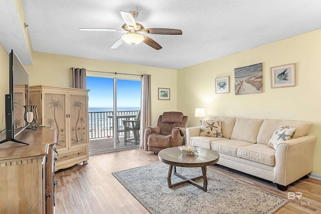 24114 Perdido Beach Blvd Unit 402, Orange Beach, AL 36561 - living room with hardwood / wood-style floors, ceiling fan, a textured ceiling, and a water view
