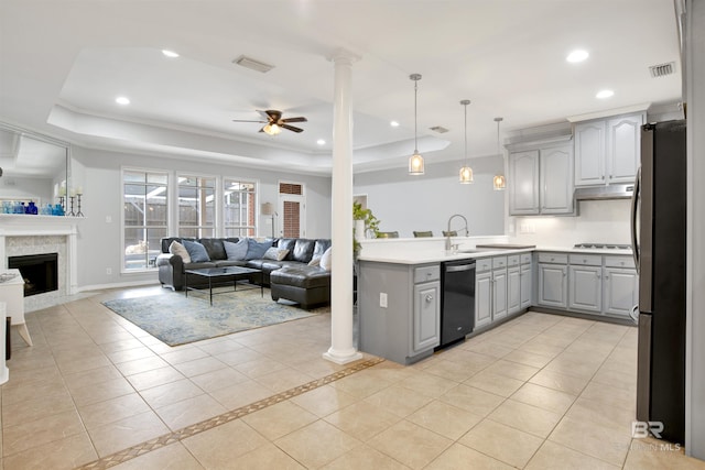 kitchen featuring a raised ceiling, gray cabinets, appliances with stainless steel finishes, ceiling fan, and pendant lighting