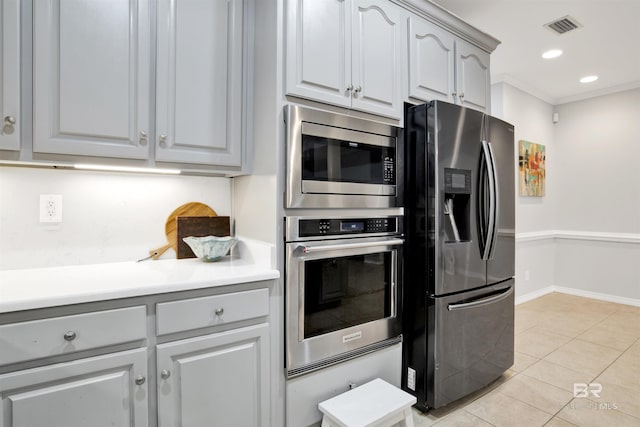 kitchen with ornamental molding, light tile patterned floors, gray cabinetry, and appliances with stainless steel finishes