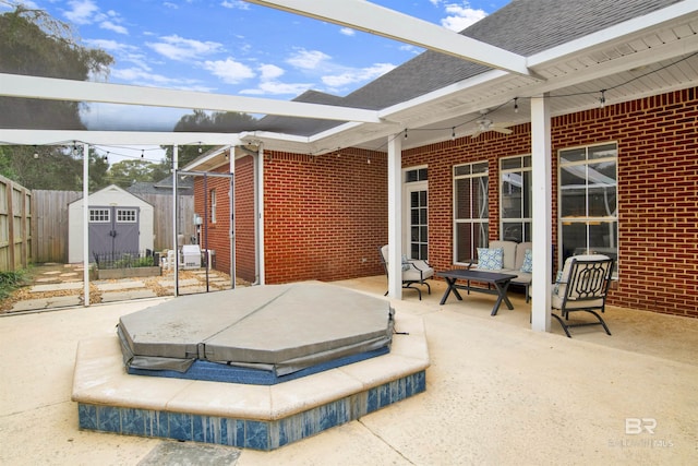 view of patio / terrace featuring a covered hot tub and a shed