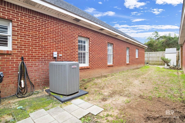 view of property exterior featuring central air condition unit and a yard