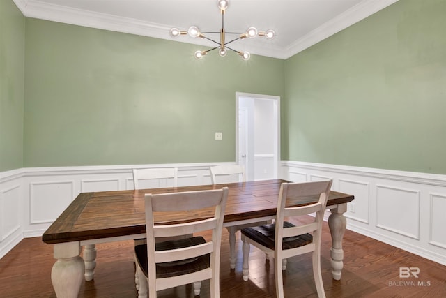 dining space with dark wood-type flooring, an inviting chandelier, and ornamental molding