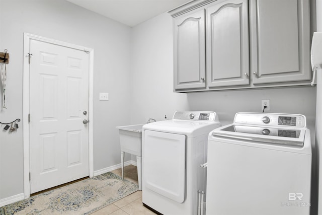 washroom with washer and dryer, cabinets, and light tile patterned floors