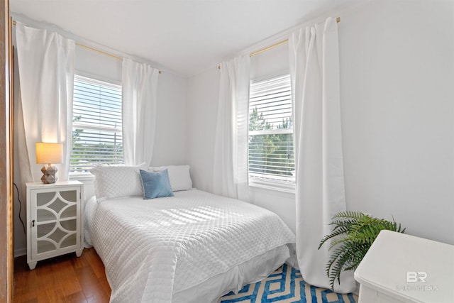 bedroom with multiple windows and wood finished floors