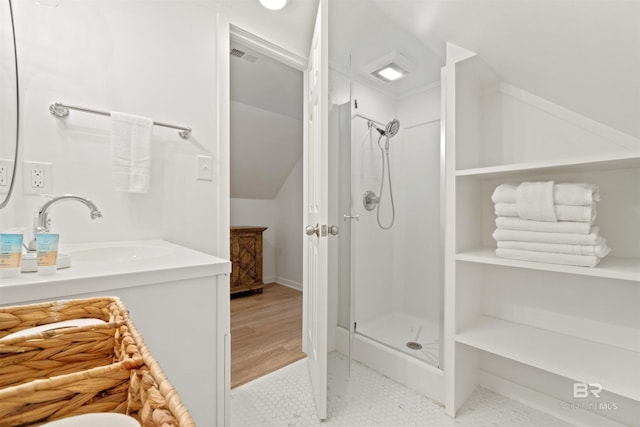 full bath with a shower stall, vanity, vaulted ceiling, and visible vents