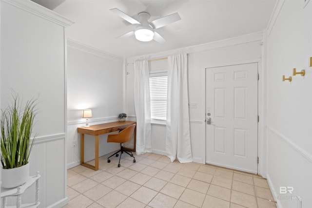 office area with light tile patterned floors, wainscoting, a ceiling fan, and crown molding
