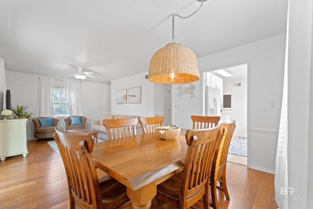 dining area featuring light wood-style floors, baseboards, visible vents, and ceiling fan