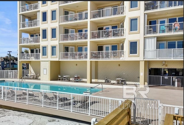 pool with a patio area and fence