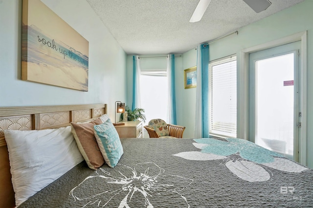 bedroom with ceiling fan and a textured ceiling