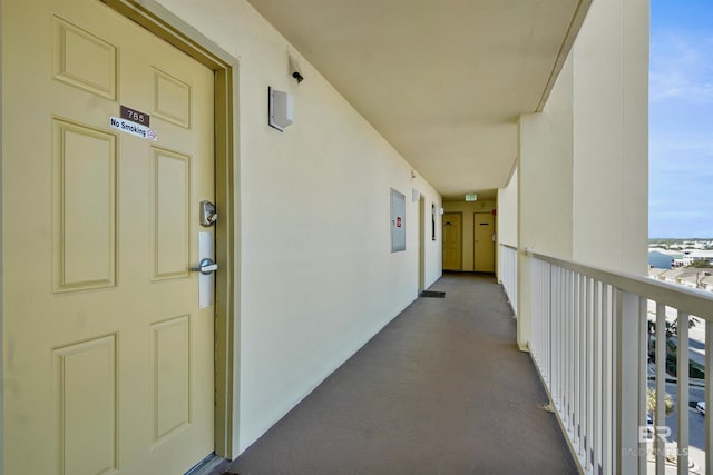 entrance to property featuring a balcony and stucco siding