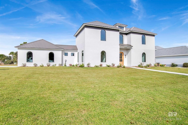 mediterranean / spanish home with a front lawn