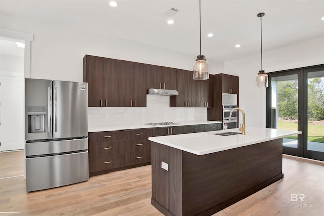 kitchen with decorative light fixtures, light wood-type flooring, stainless steel appliances, and french doors