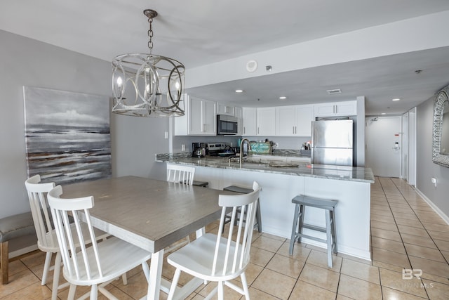 tiled dining room featuring a notable chandelier and sink