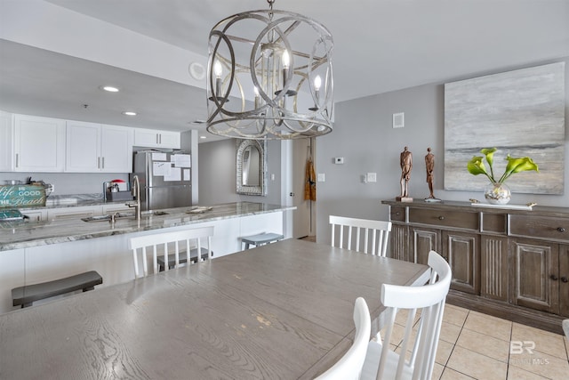 dining room featuring an inviting chandelier, sink, and light tile patterned floors