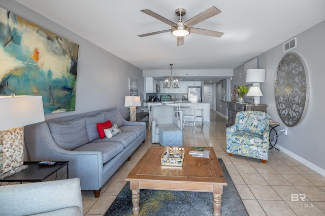 living room featuring ceiling fan with notable chandelier and light tile patterned flooring