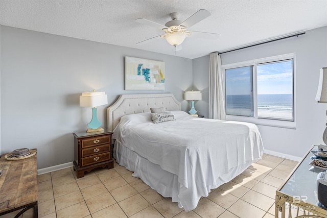 bedroom with light tile patterned floors, a textured ceiling, and ceiling fan