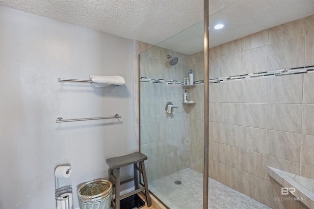 bathroom featuring tiled shower and a textured ceiling
