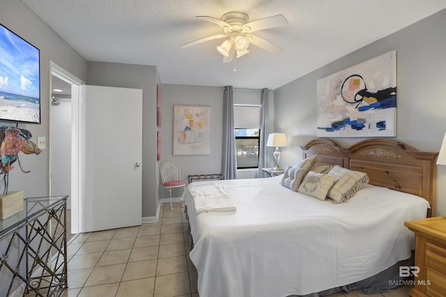 tiled bedroom featuring ceiling fan and a textured ceiling