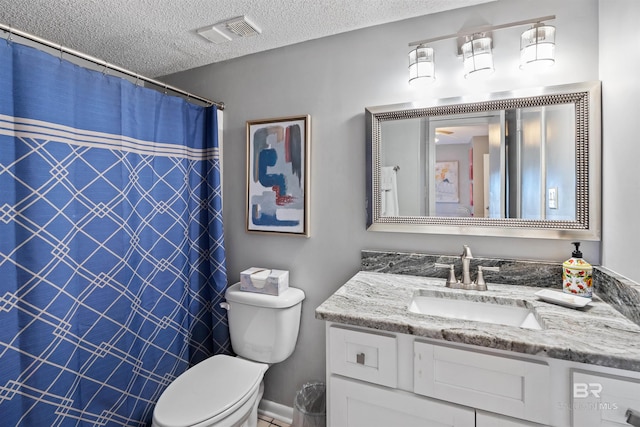 bathroom featuring vanity, toilet, and a textured ceiling