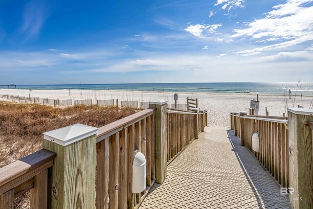 view of community featuring a water view and a beach view