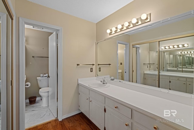 389 Clubhouse Dr Unit 4R, Gulf Shores, AL 36542 - full bathroom with toilet, baseboards, vanity, and wood finished floors