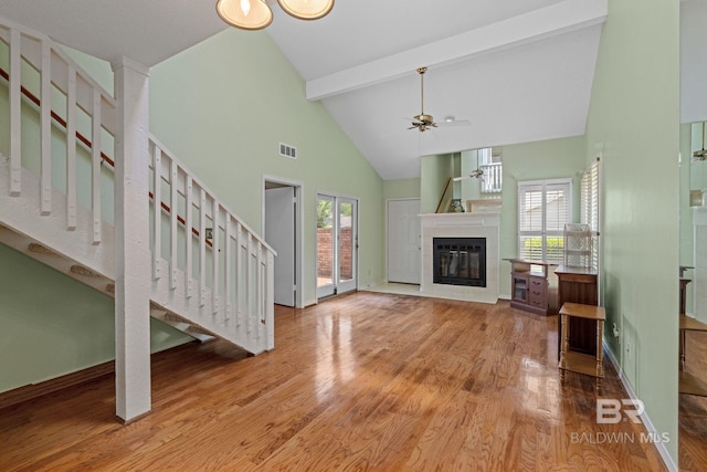 389 Clubhouse Dr Unit 4R, Gulf Shores, AL 36542 - unfurnished living room featuring high vaulted ceiling, beam ceiling, wood finished floors, stairway, and ceiling fan