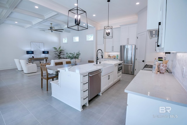 kitchen featuring a kitchen island with sink, coffered ceiling, stainless steel appliances, and white cabinetry