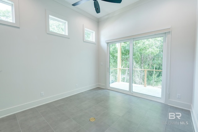 tiled empty room with ceiling fan and ornamental molding