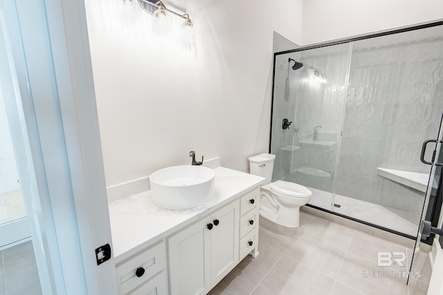 bathroom featuring toilet, vanity, tile patterned floors, and a shower with shower door