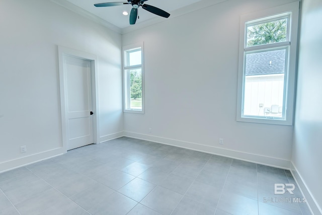 tiled spare room featuring ceiling fan and ornamental molding