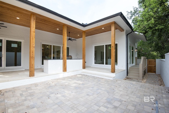 back of property with ceiling fan and a patio area