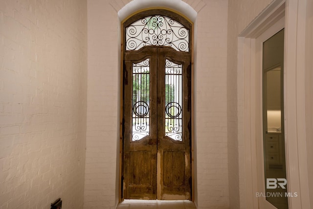 entryway featuring brick wall and french doors