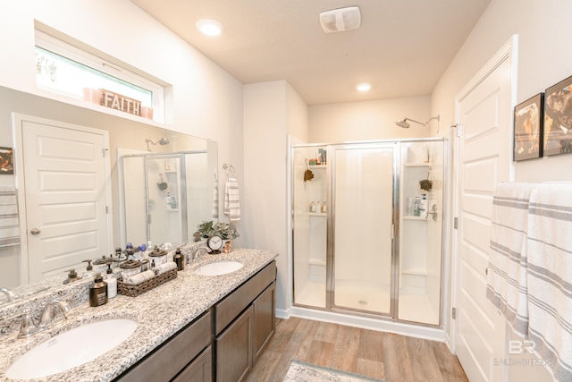 bathroom featuring vanity, an enclosed shower, and wood-type flooring