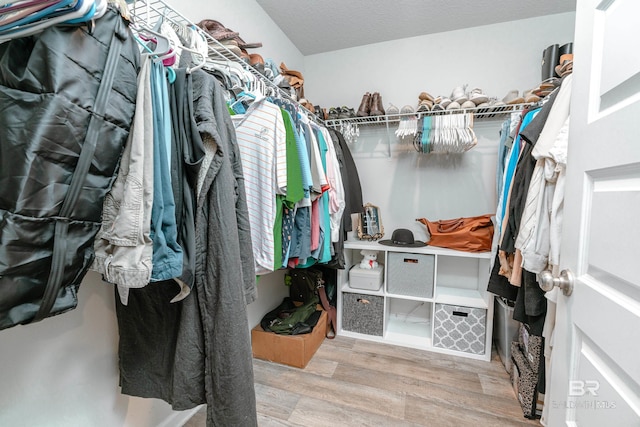 walk in closet with light hardwood / wood-style flooring