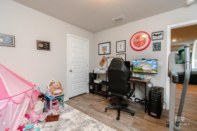 office featuring a textured ceiling and light hardwood / wood-style flooring