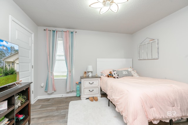 bedroom featuring hardwood / wood-style flooring and a textured ceiling