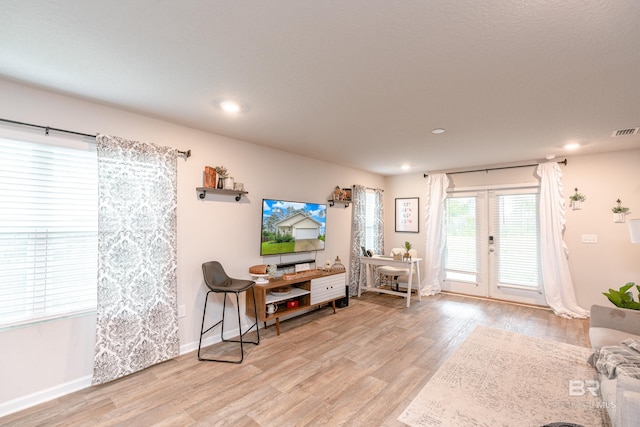 interior space with light wood-type flooring and french doors