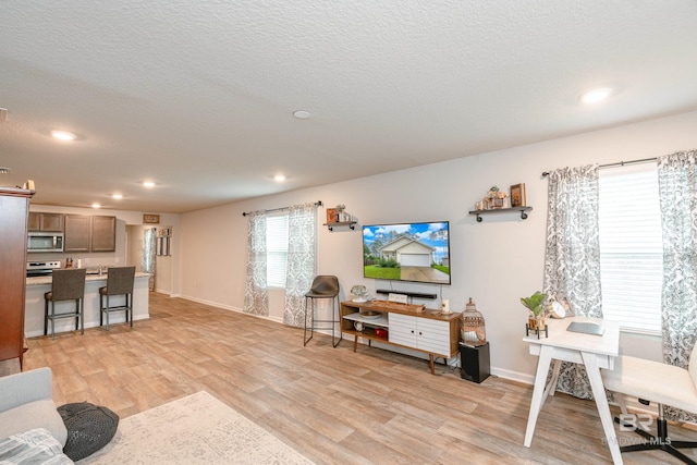 living room featuring light wood-type flooring and a textured ceiling