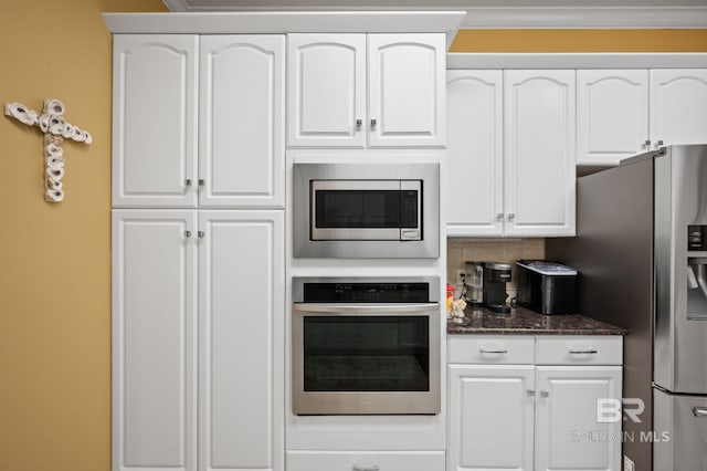 137 Mcintosh Bluff Rd, Fairhope, AL 36532 - kitchen featuring stainless steel appliances, white cabinetry, dark stone counters, and decorative backsplash
