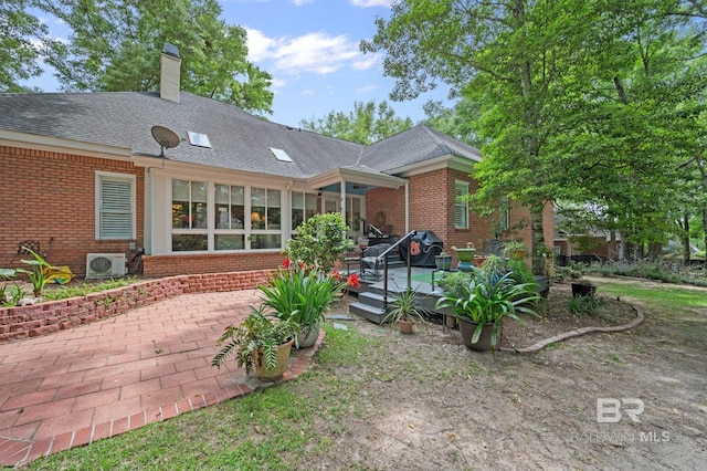 137 Mcintosh Bluff Rd, Fairhope, AL 36532 - rear view of property with brick siding, a cooling unit, a deck, a chimney, and a patio area