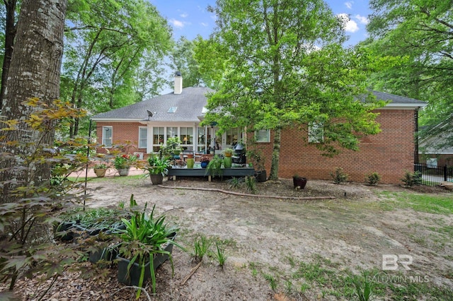 137 Mcintosh Bluff Rd, Fairhope, AL 36532 - back of property with brick siding, a deck, a chimney, and fence