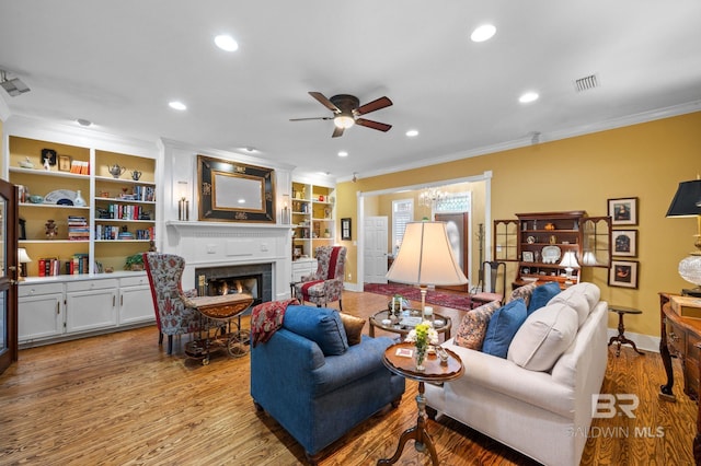 137 Mcintosh Bluff Rd, Fairhope, AL 36532 - living area with crown molding, ceiling fan, a warm lit fireplace, wood finished floors, and baseboards