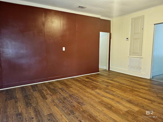 unfurnished room with wood-type flooring and a textured ceiling