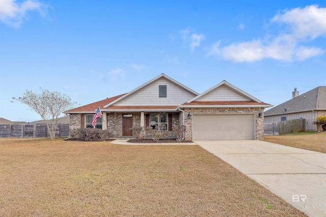 view of front of house with brick siding, fence, concrete driveway, a front yard, and a garage