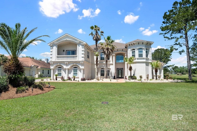 rear view of house featuring a yard and a balcony